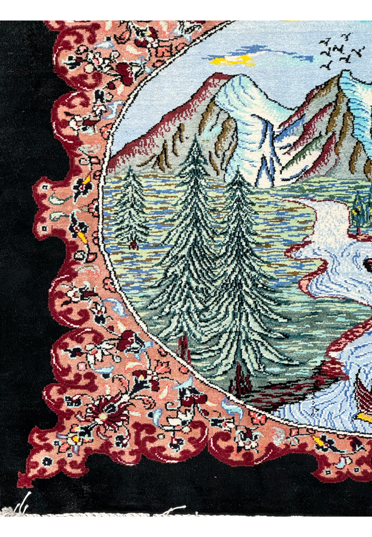 Corner detail of a Persian Qum silk rug with a richly decorated border and a glimpse of the pastoral central design