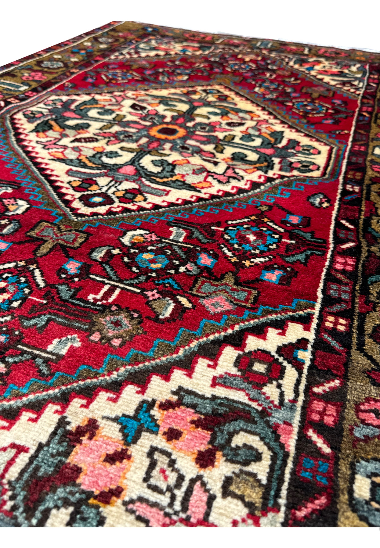 Angled view of the Persian Hamedan rug displaying the plush pile and ornate designs