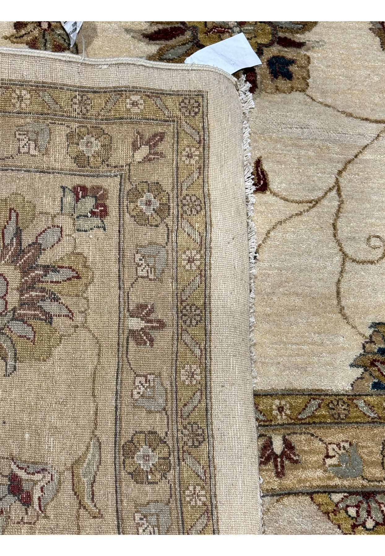 Close-up of the rug's fringe and corner craftsmanship with visible weave structure