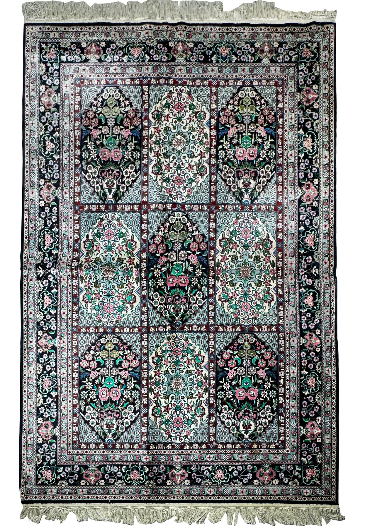 Close-up of the intricate floral and geometric patterns on a Persian Qum silk rug with shimmering silk threads