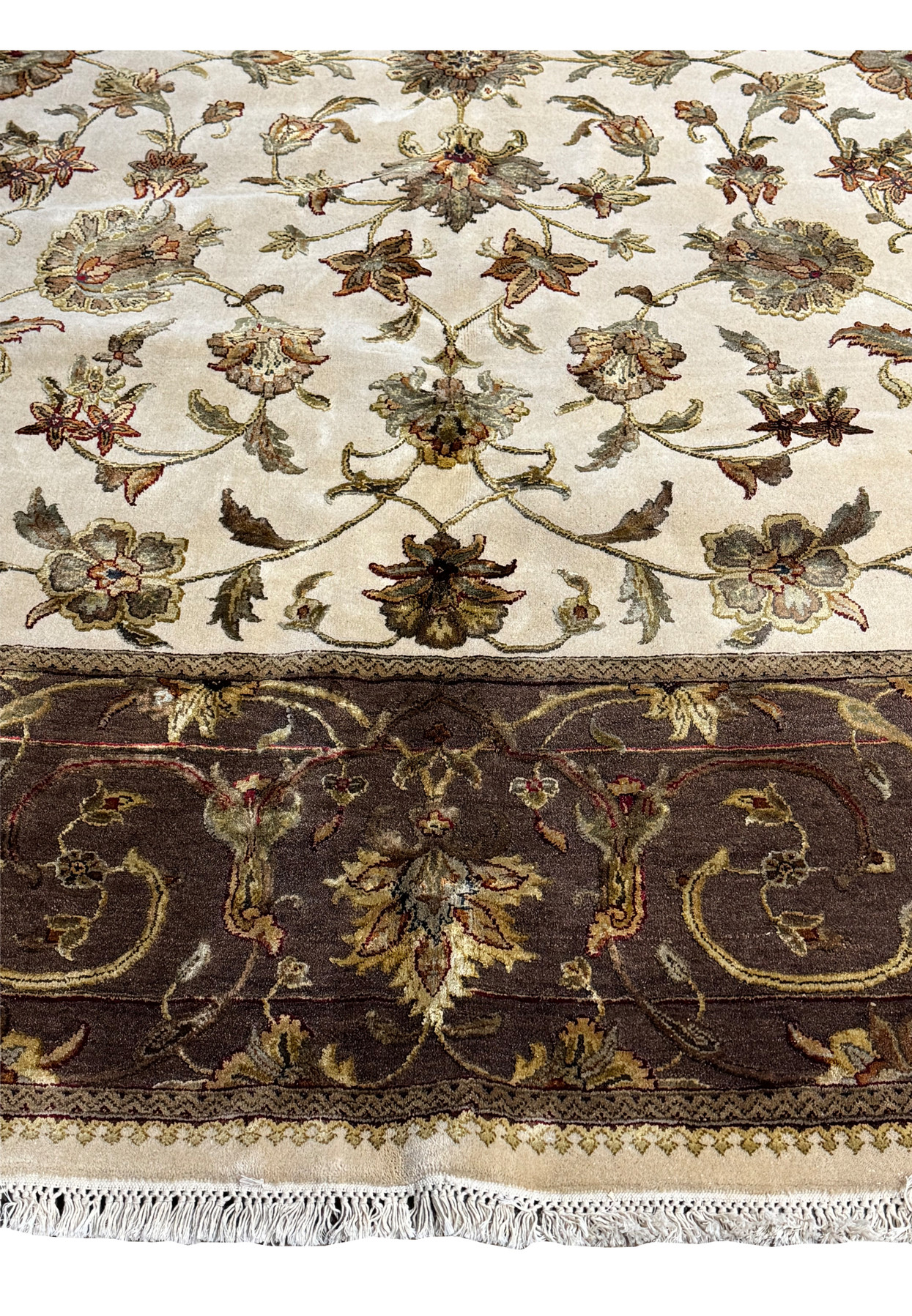 An angled view of the Indian Chobi rug, displaying the rich texture and color variation within the central floral design and border.