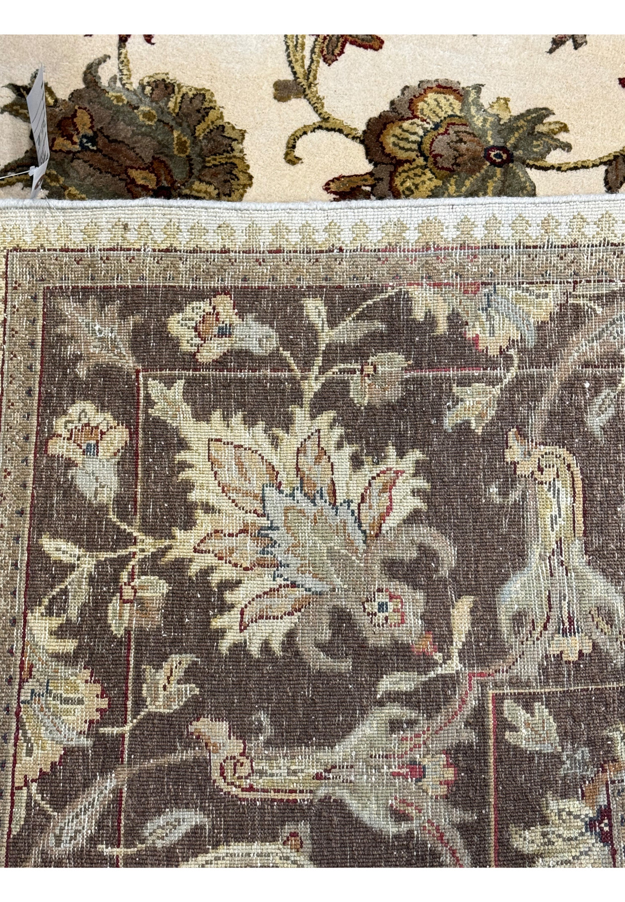 A close-up of the Chobi rug's border and fringe, showcasing the detailed patterns and texture of the rug's edge.