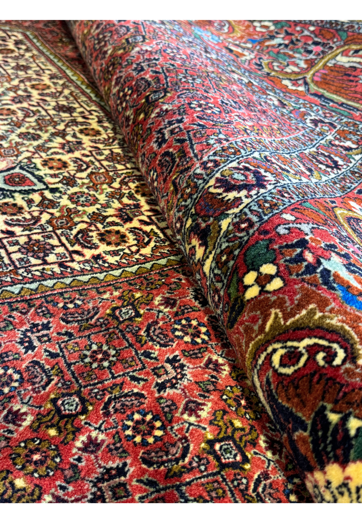 A close-up of the Bijar rug's weave, highlighting the high knot density and the detailed design work of the borders and field