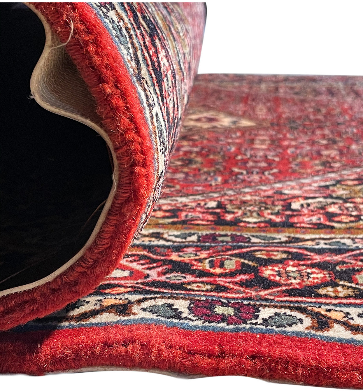 Rolled-up Persian Bijar rug, showcasing the density of the weave and the rug's side profile