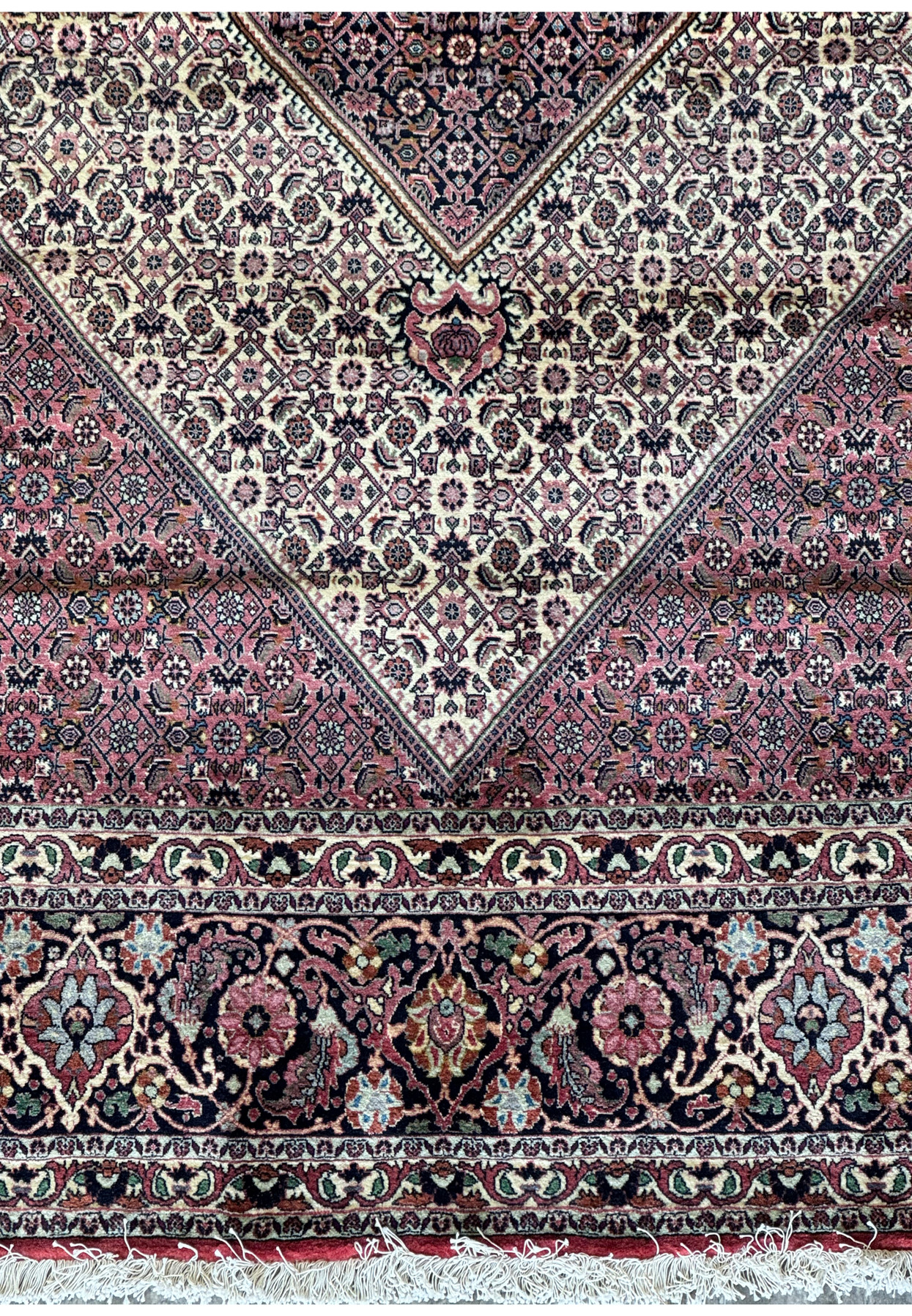 Close-up on the central medallion of a Persian Bijar rug, emphasizing the detailed craftsmanship and ornate floral elements.