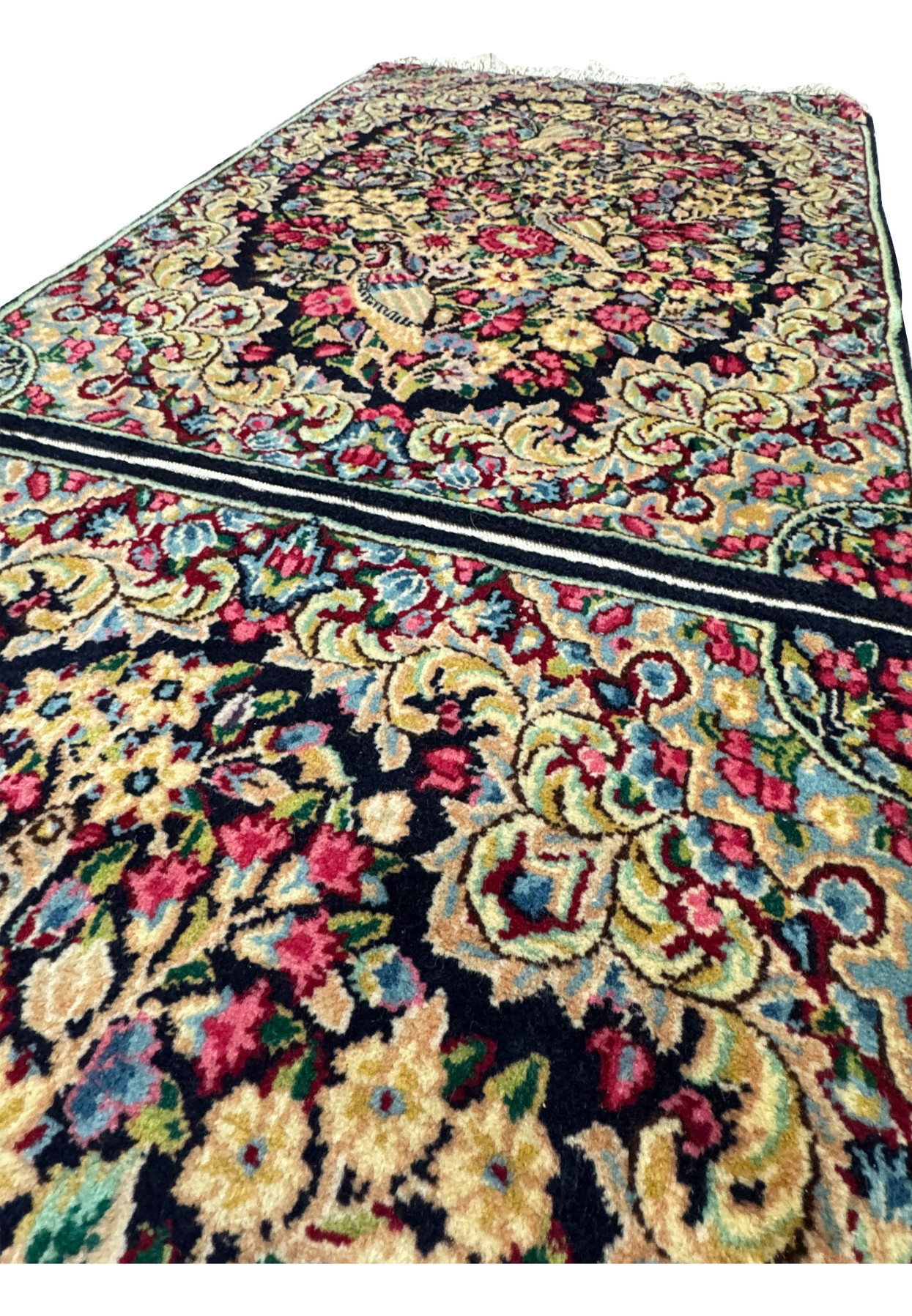 Side view of a Persian Kerman rug, illustrating the thickness and quality of the dual rugs woven together.