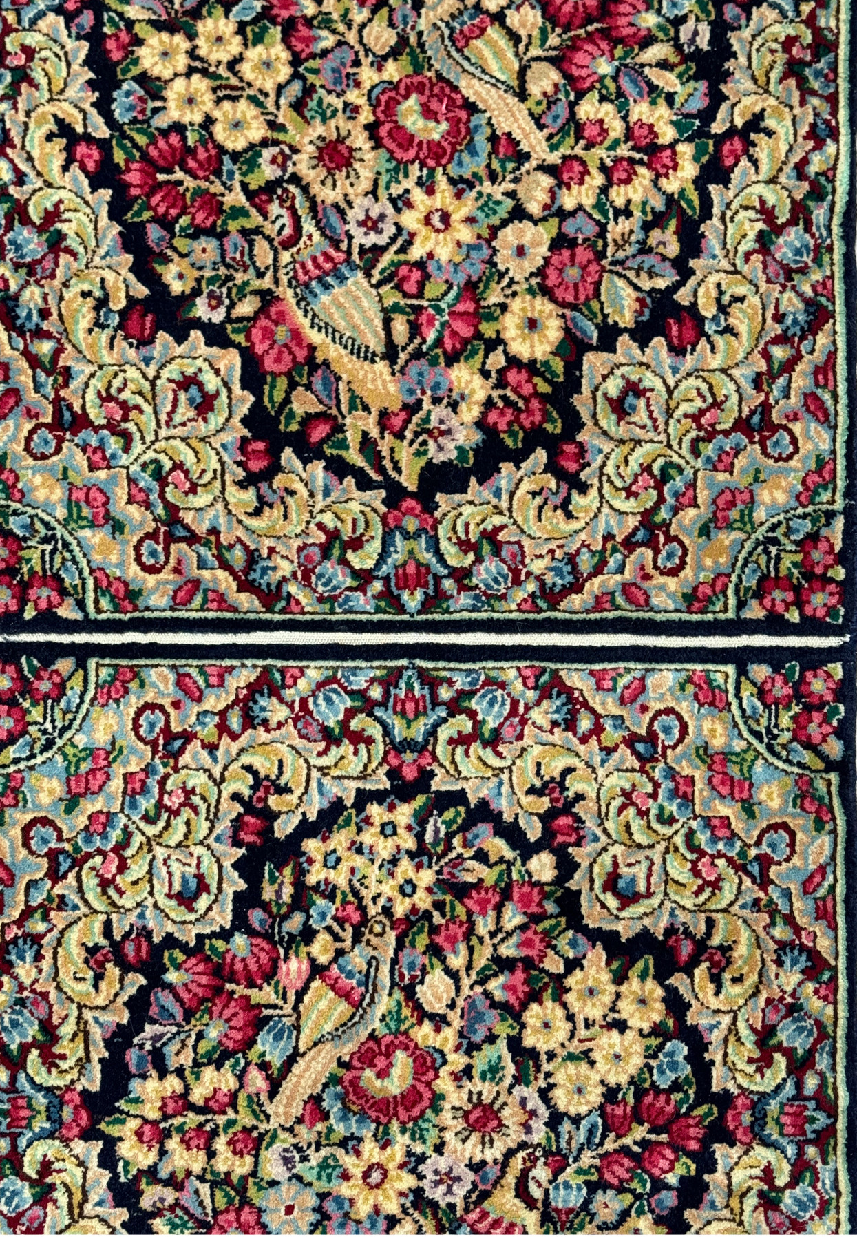 Zoomed-in section of a Persian Kerman rug displaying the fine details and color variations in the weave.