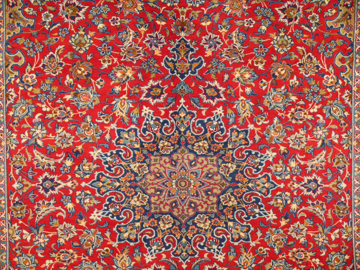 close up of majestic central medallion of a 10x13 Isfahan Persian rug with deep red tomato red background