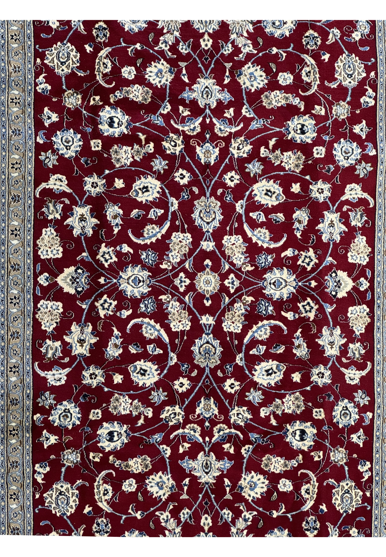 Close-up of the central pattern of the Persian Nain 9La rug, highlighting the detailed floral designs in cream and blue on a rich red background