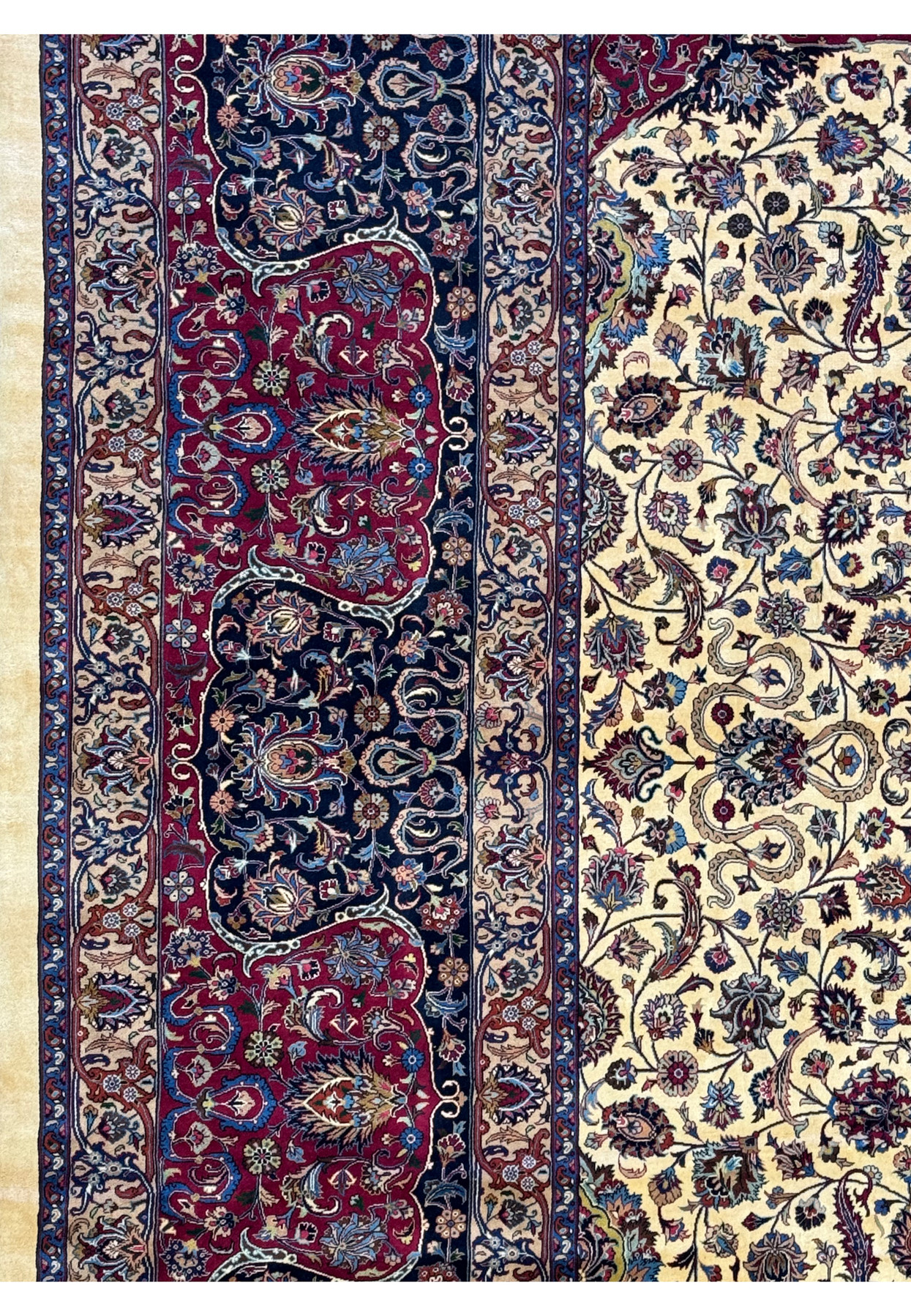 Detailed close-up of the border on a Persian Mashad rug, showcasing elaborate floral designs and traditional Persian motifs in deep red, blue, and beige, highlighting the rug's meticulous craftsmanship and vibrant color palette