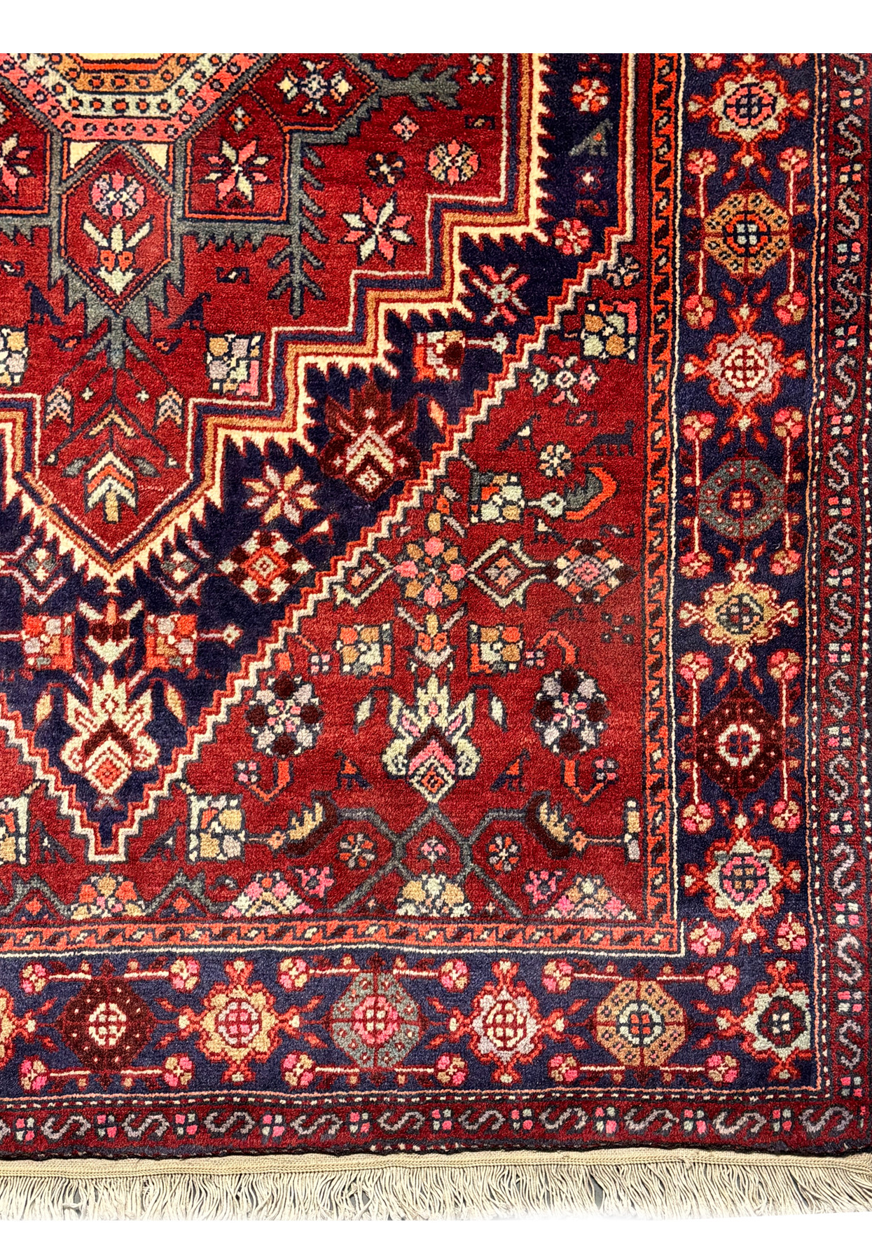 Close-up of the texture and intricate patterns of a 3'4" x 5'1" Persian Gholtogh Rug. The vibrant red field is adorned with detailed geometric and floral motifs, showcasing the rich colors and exquisite craftsmanship of traditional Persian rug-making