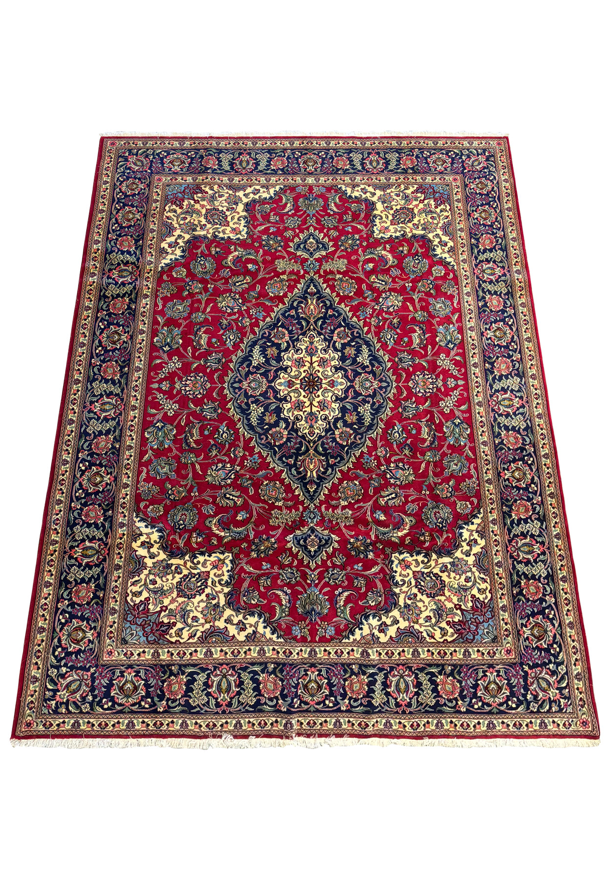 close-up view of the central medallion in a Persian Qum Kork Rug, showcasing intricate floral patterns in blue, cream, and gold on a rich red background.