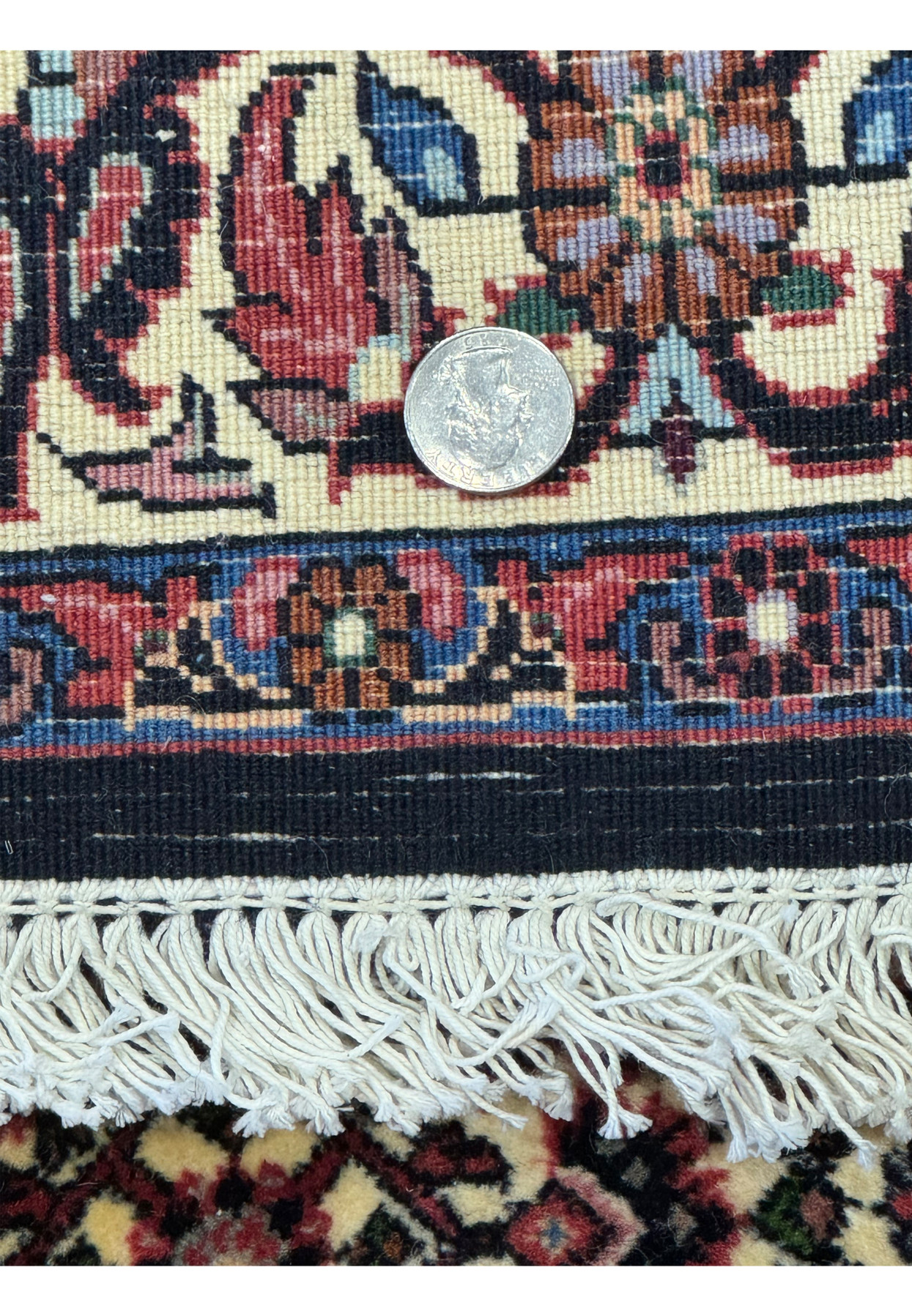 Back of the Persian Bijar Rug with a coin for scale, showing the dense weave and high-quality construction.