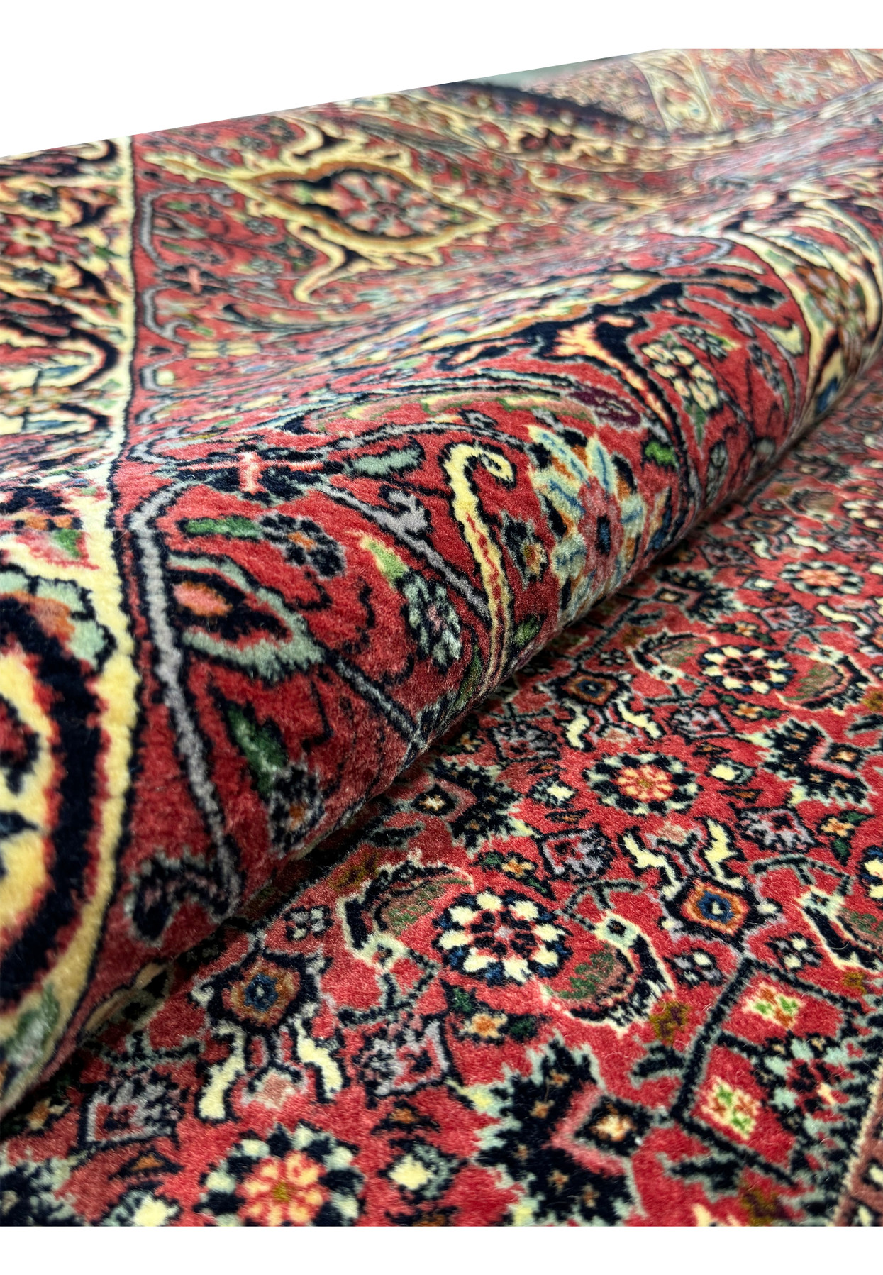 Detailed shot of the Persian Bijar Rug rolled up, highlighting the vibrant colors and fine craftsmanship