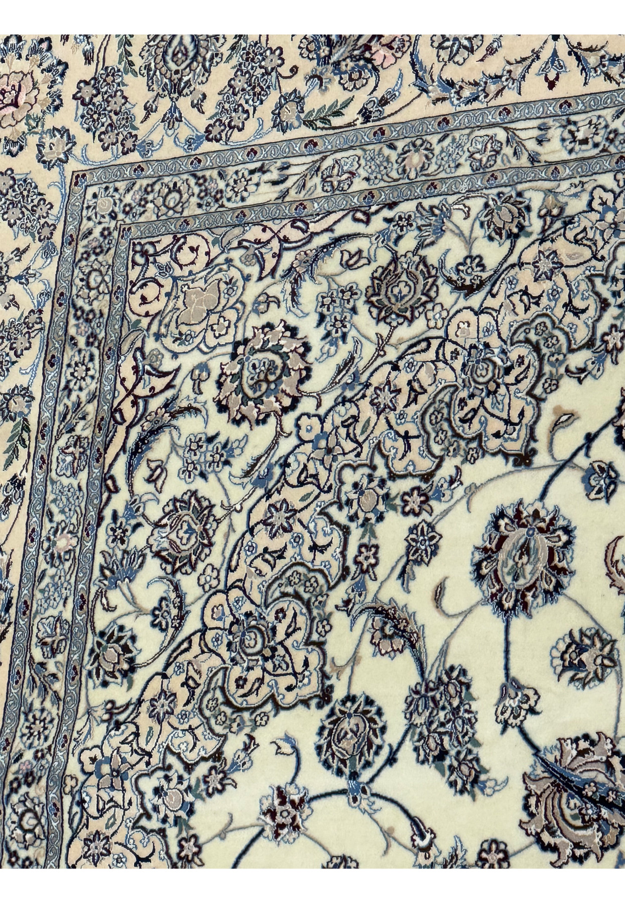 Angle view highlighting the floral border and field of a Persian Nain 9LAA Wool & Silk Rug.
