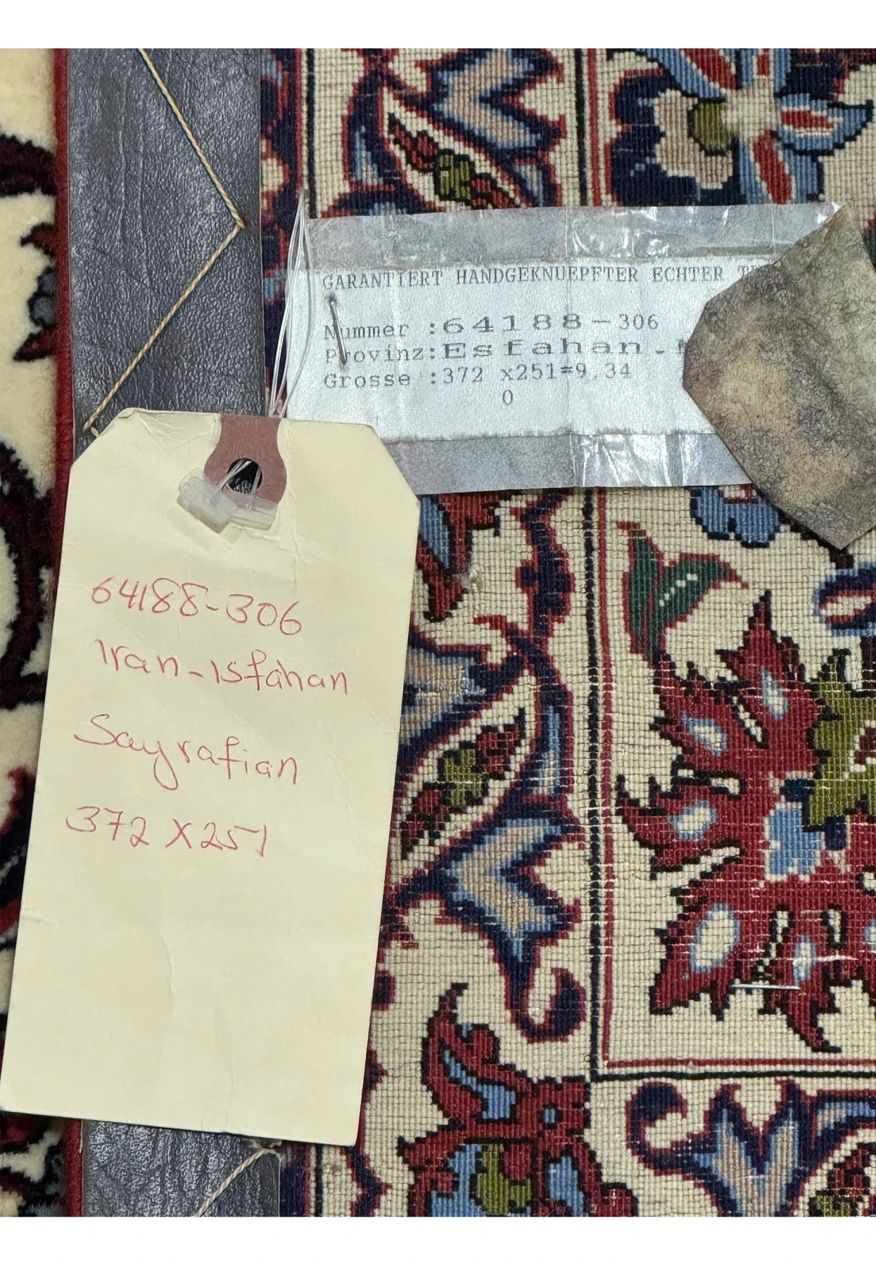 Close-up of label and handwritten tag on the back of Persian Isfahan Silk Rug, indicating its authenticity.