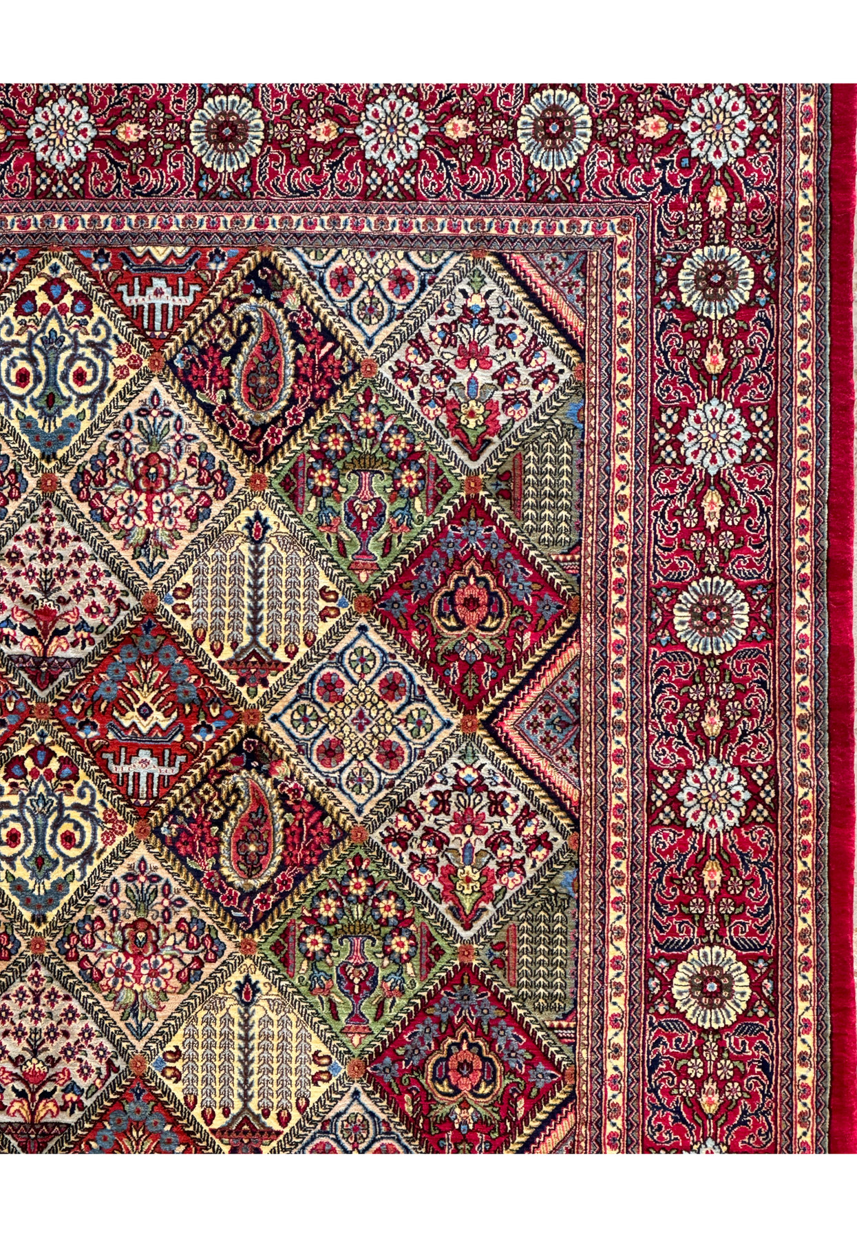 Close-up of the border design on a Persian Qum rug, showcasing floral rosettes and vine patterns in contrasting colors