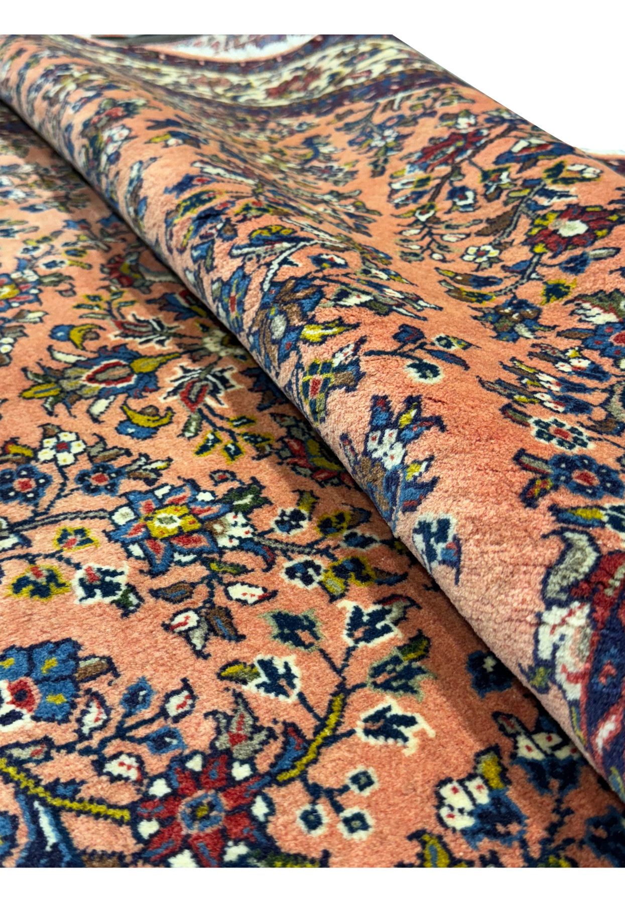 Rolled edge of the 5'6" x 8'5" Persian Sarouk rug showing the back weave and thickness.