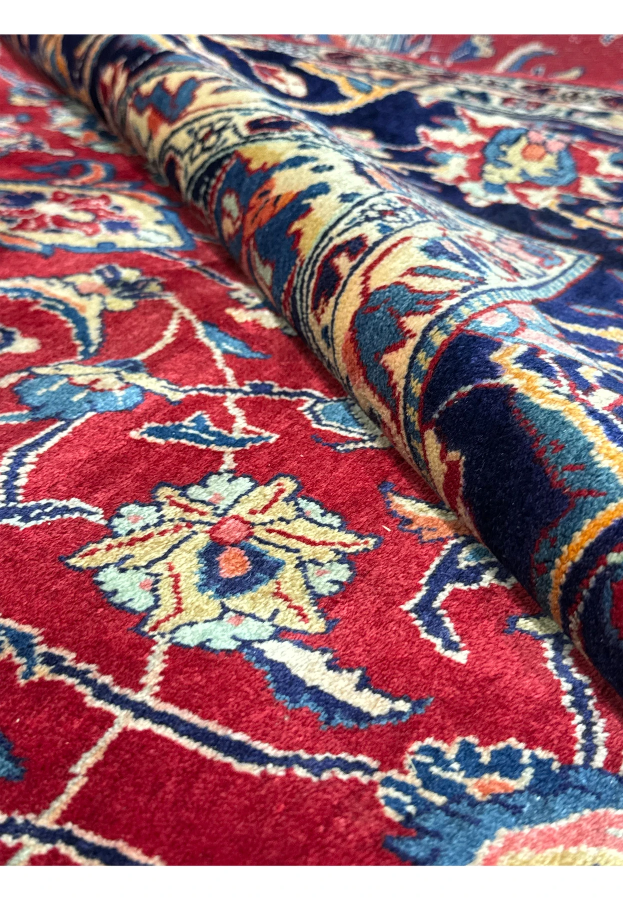 exture view of the 9 x 13 Persian Sarough Rug rolled up, highlighting the luxurious wool and intricate designs.