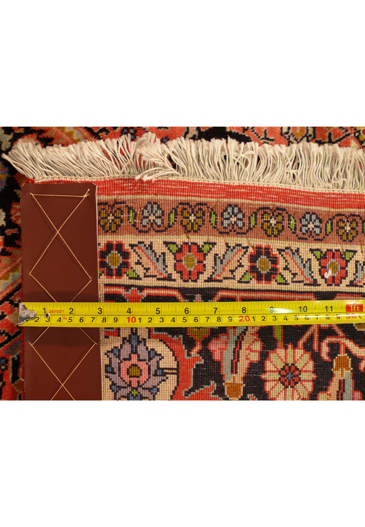 Close-up of the 8'2 x 11'4 Persian Bijar Rug's backside, highlighting the density and high quality of the weave with a measuring tape for scale.