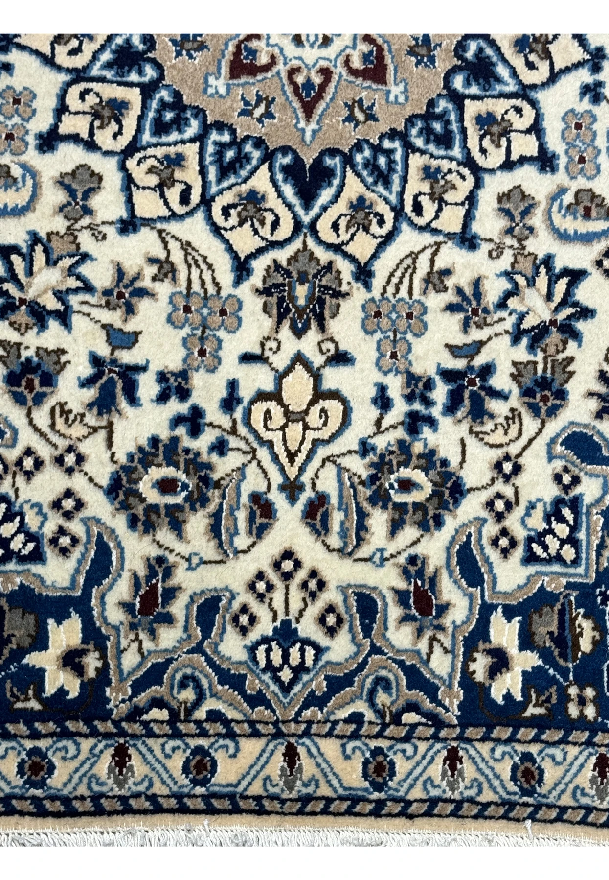 Lower part of the Persian Nain rug highlighting the border design and floral patterns with silk accents.
