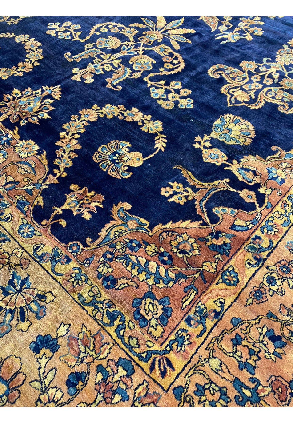 Detailed view of the corner of the Persian Kerman Lavar rug with floral border design