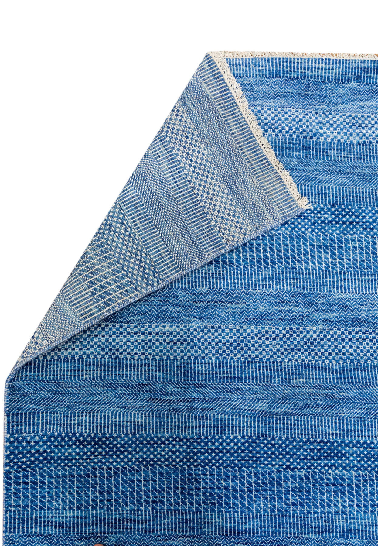 Close-up of the folded edge showing texture of blue 12x18 rug