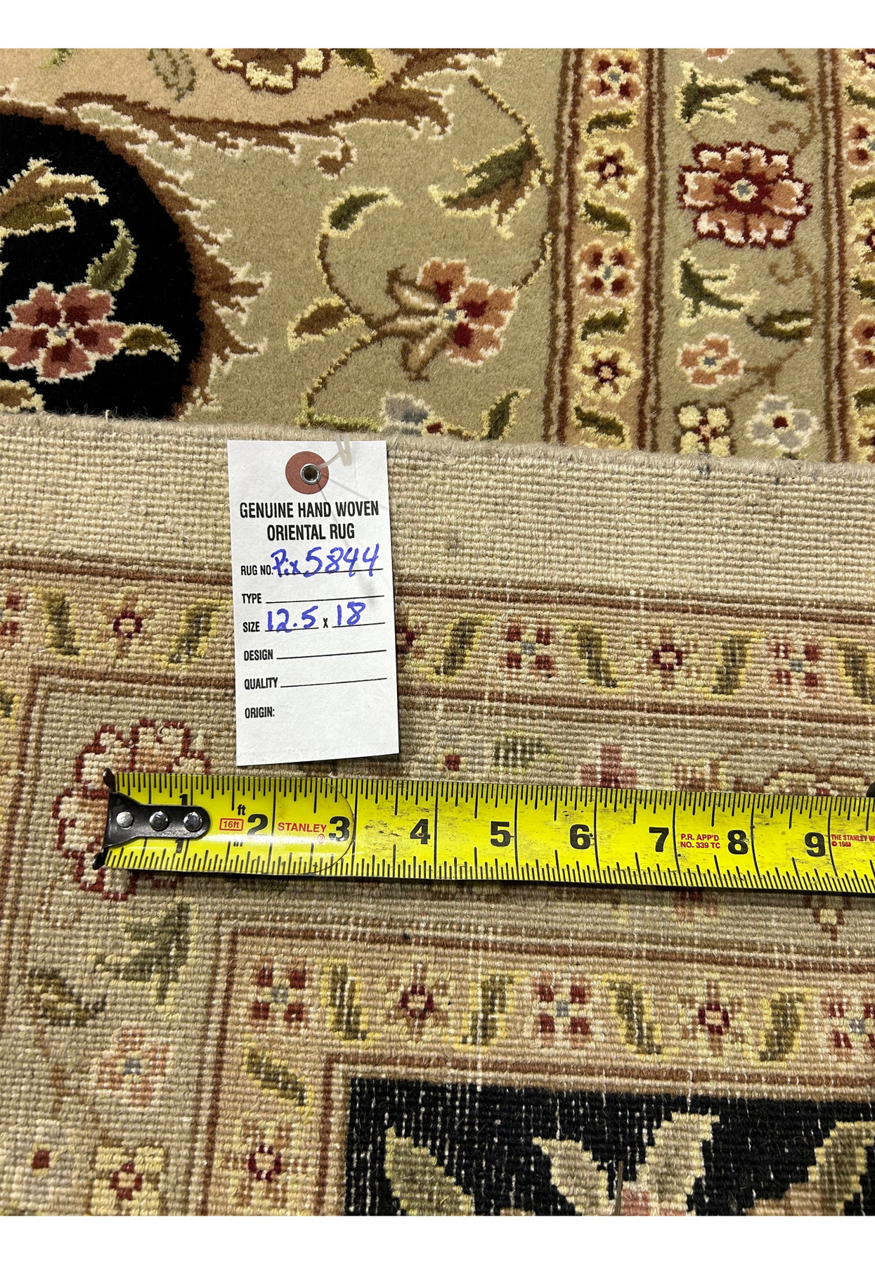 Close-up of the genuine handwoven label on a 12'5" x 18' Persian Tabriz Rug, showcasing meticulous craftsmanship and traditional design.