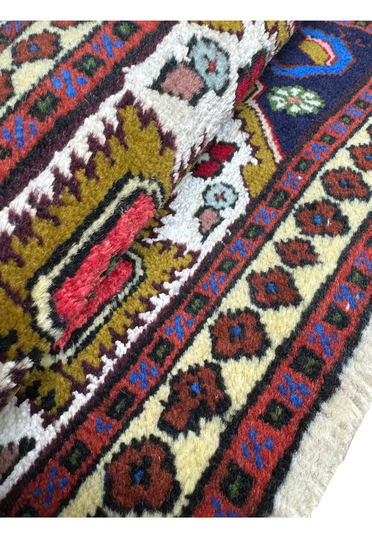 Rolled view of the 1'3 x 2' Persian Ardebil Baby Rug showing the plush wool pile and intricate design.