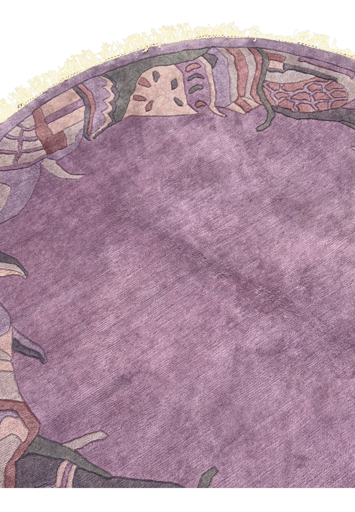 Close-up of the midfield section of the Nepali Art Deco Round Rug, highlighting the rich lavender central field.