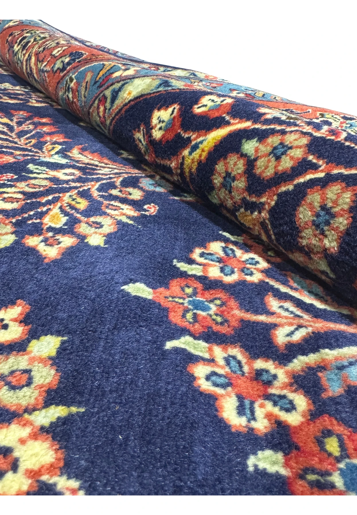 Rolled view of Persian Sarough rug displaying wool texture and detailed designs.
