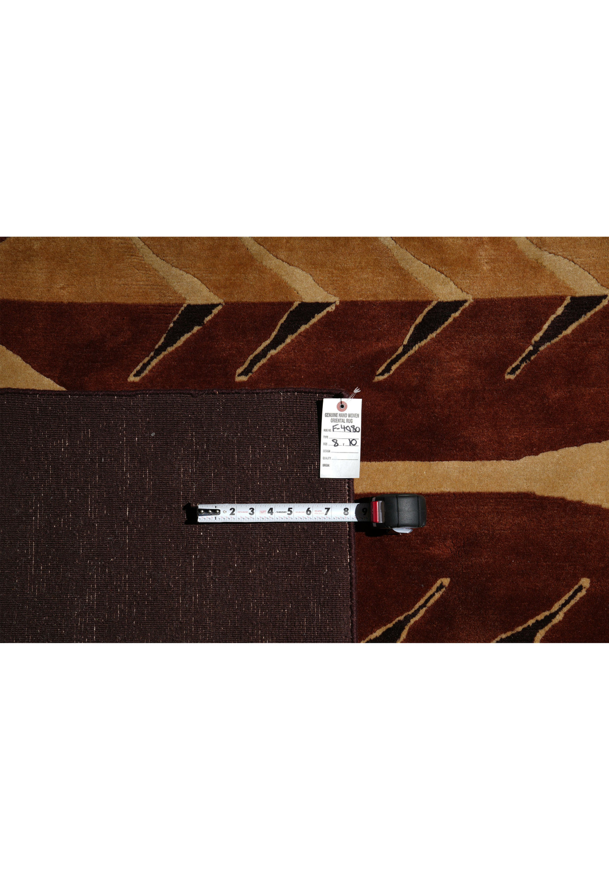 Backside of modern handmade rug showing weave and label details