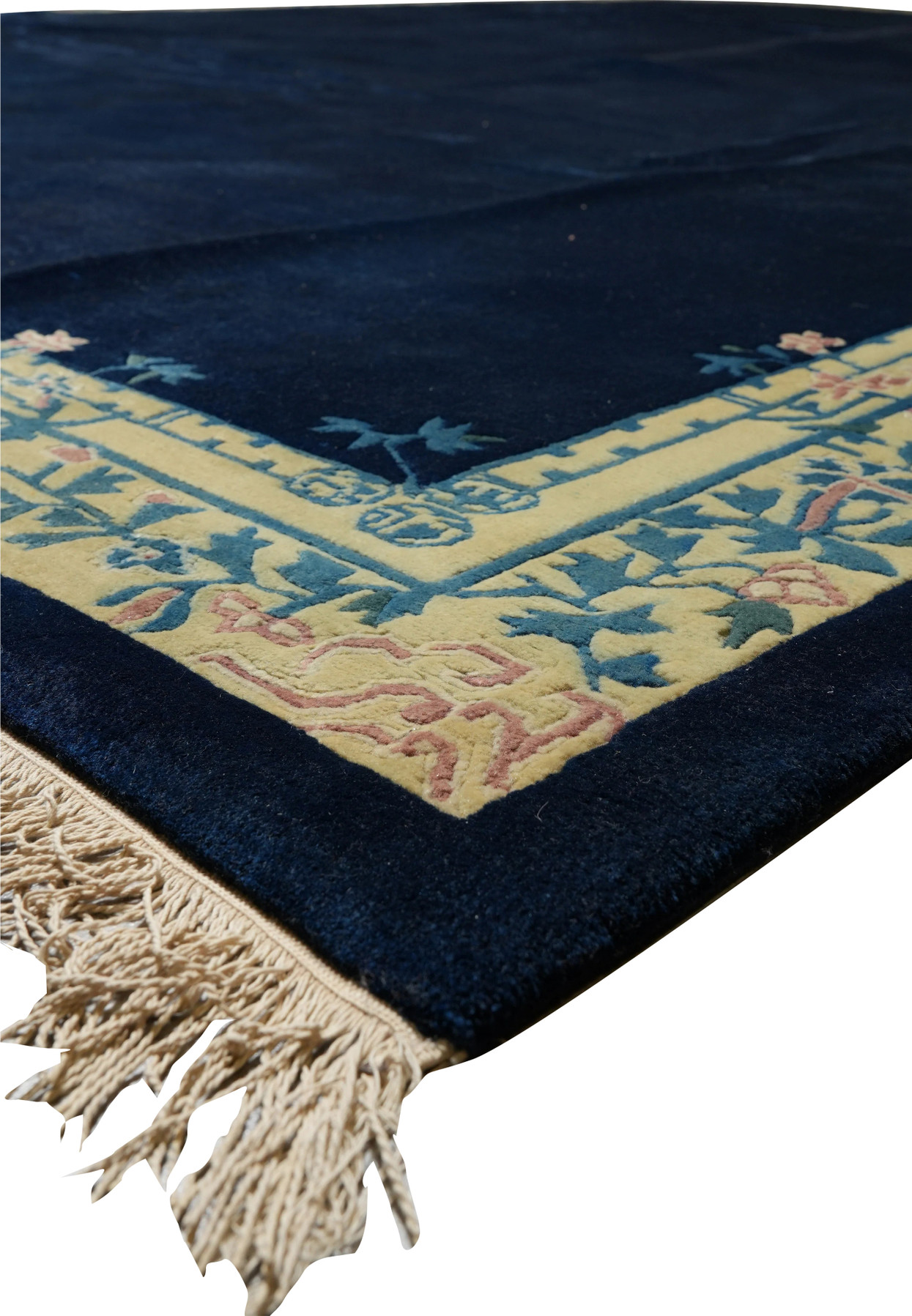 Angled view of Beijing Art Deco rug showing floral border and ivory fringe.