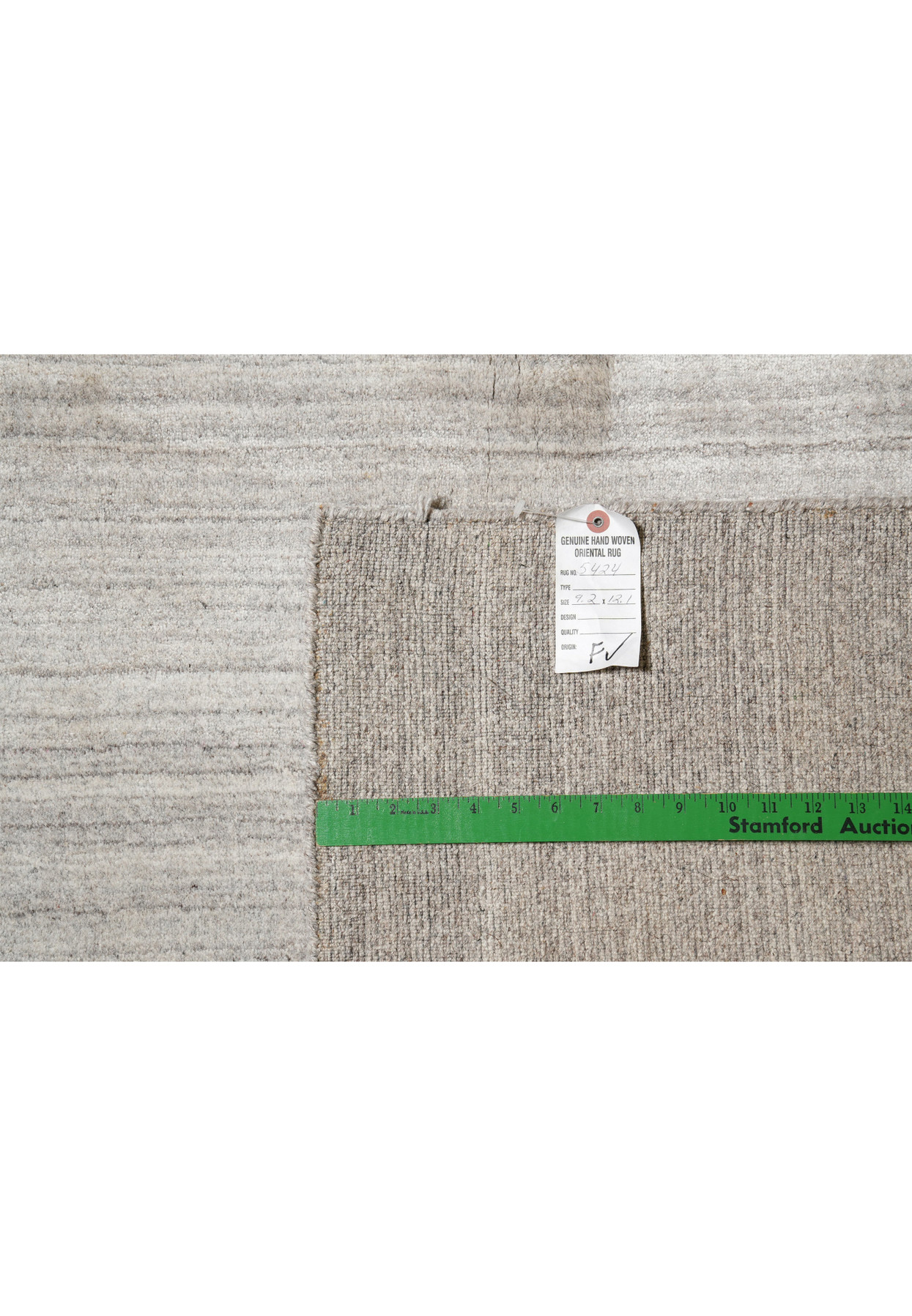 Backside of 9.2 x 12.1 solid gray wool handmade rug showing weave quality and tag