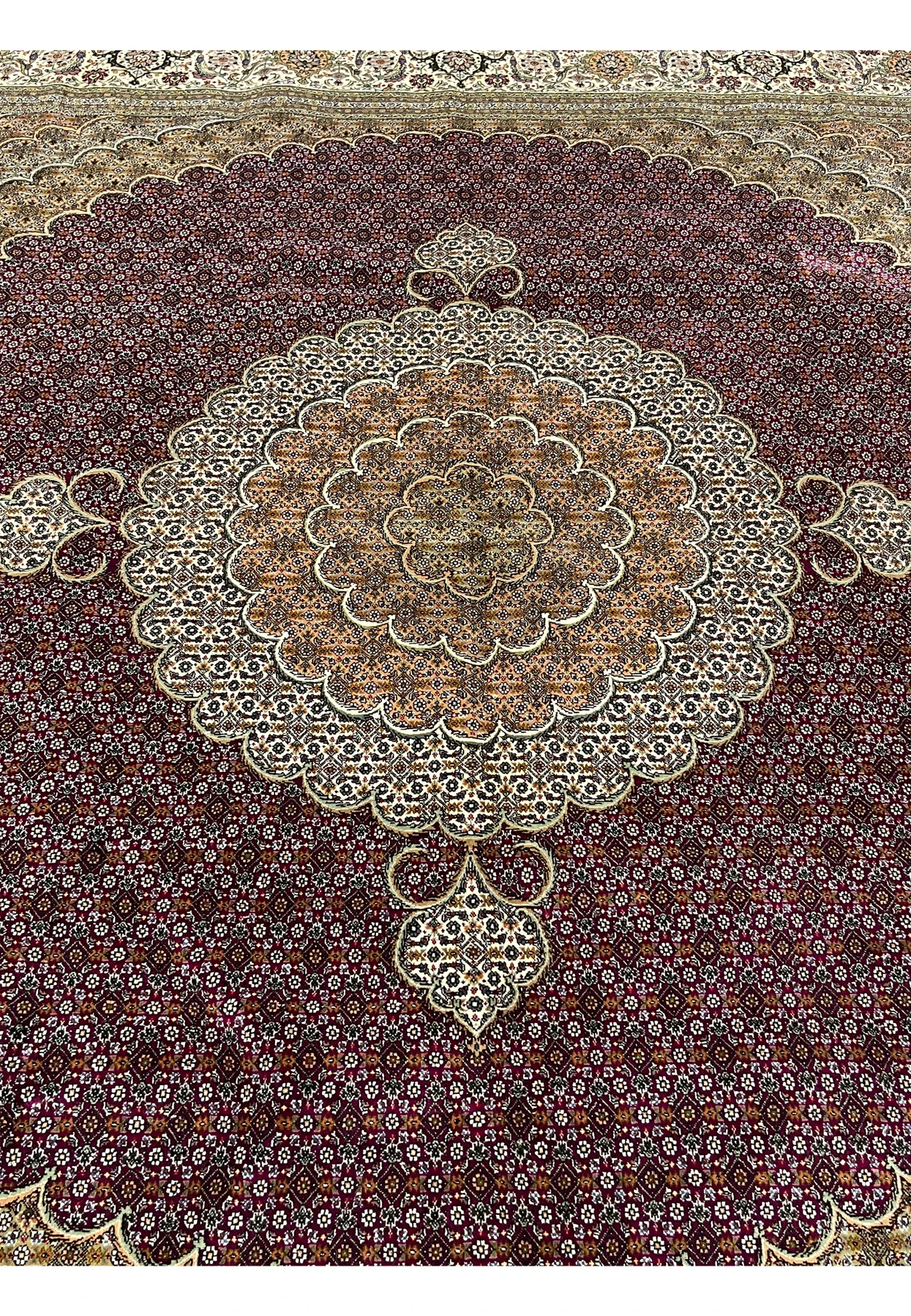 Close-up of Tabriz 50 Raj Persian Rug showing repeating Mahi fish design with wine red, ivory, and green details