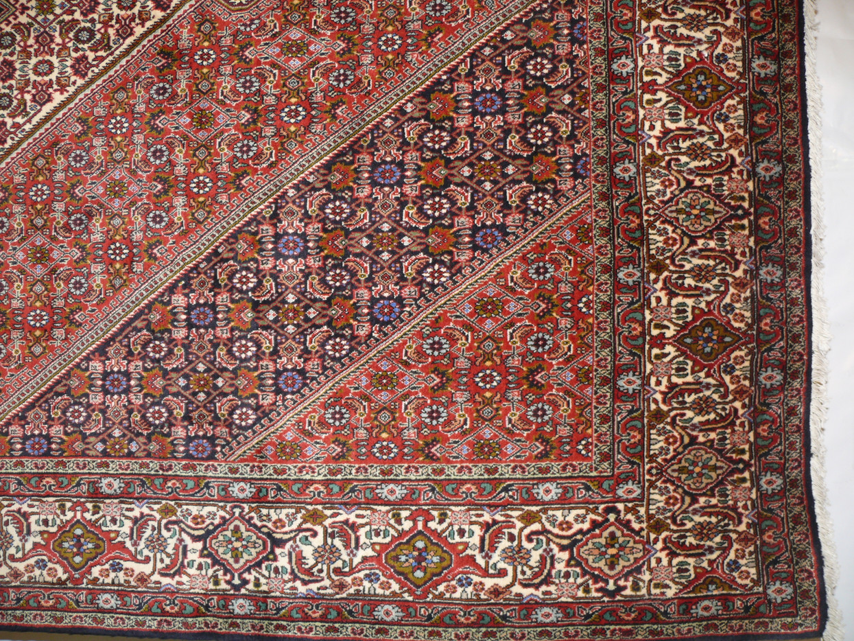 Edge detail of Persian Bijar rug 6'8 x 10'6 with red field and ivory border motifs