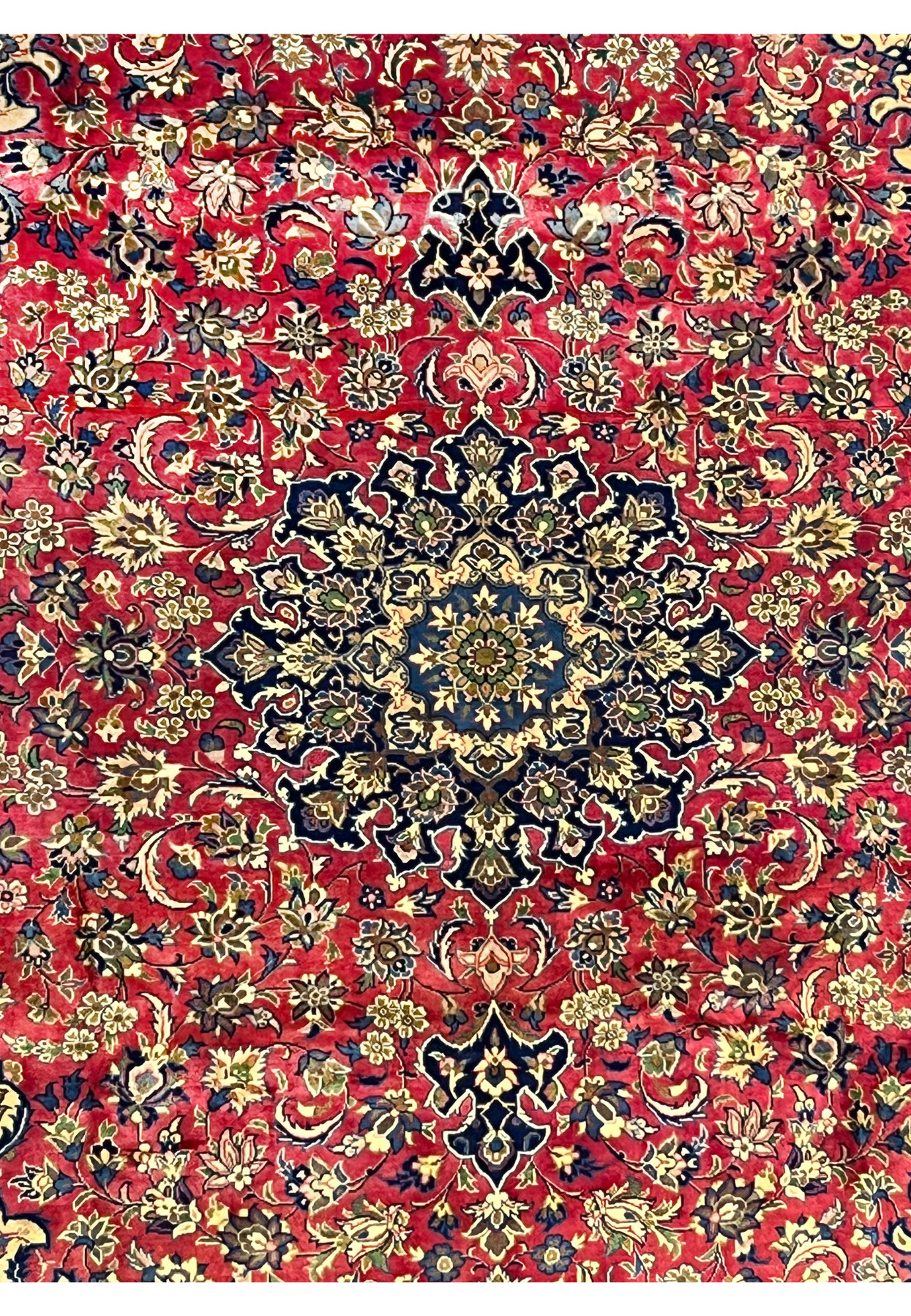 Close view of the central navy medallion surrounded by beige floral elements on a vibrant red background.