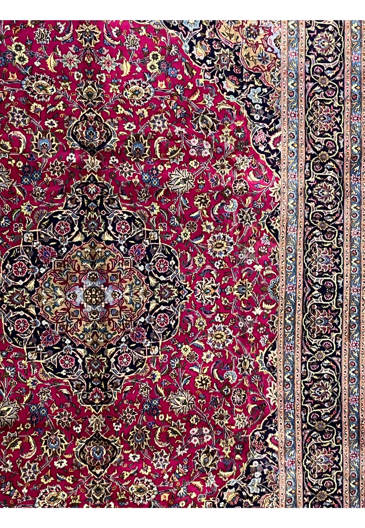 Side field detail of Mashad red rug showing floral designs and ivory highlights.