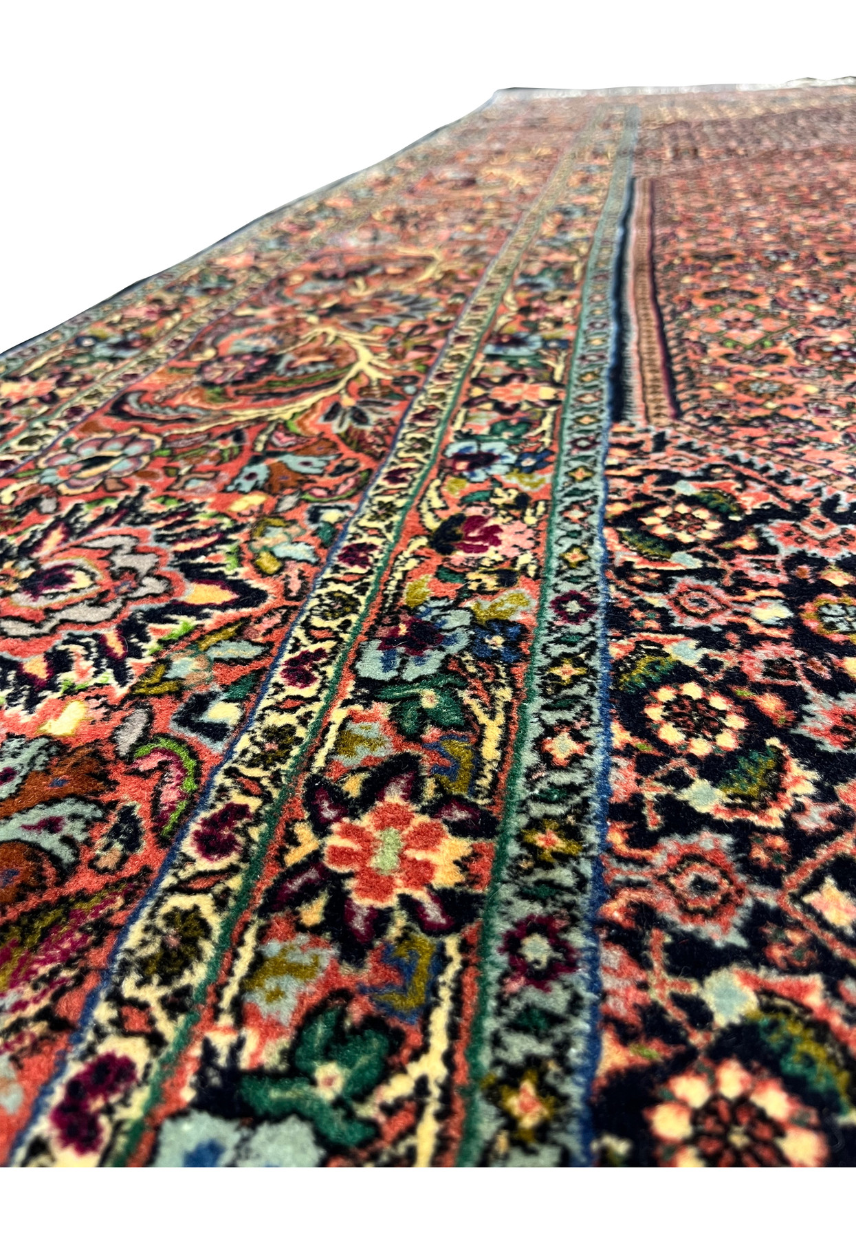 Color detail of Bijar rug showing brick red field, navy outlines, green leaves, and sky blue highlights.
