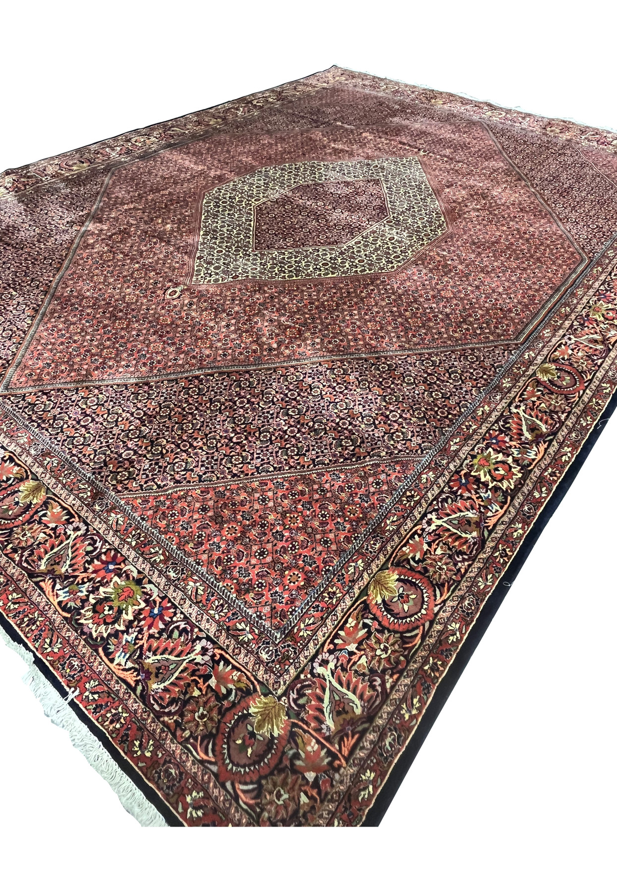 Angled low view of the 9'9 x 13'2 Bijar Persian Iron Rug showing the large cream medallion and brick red Herati field.