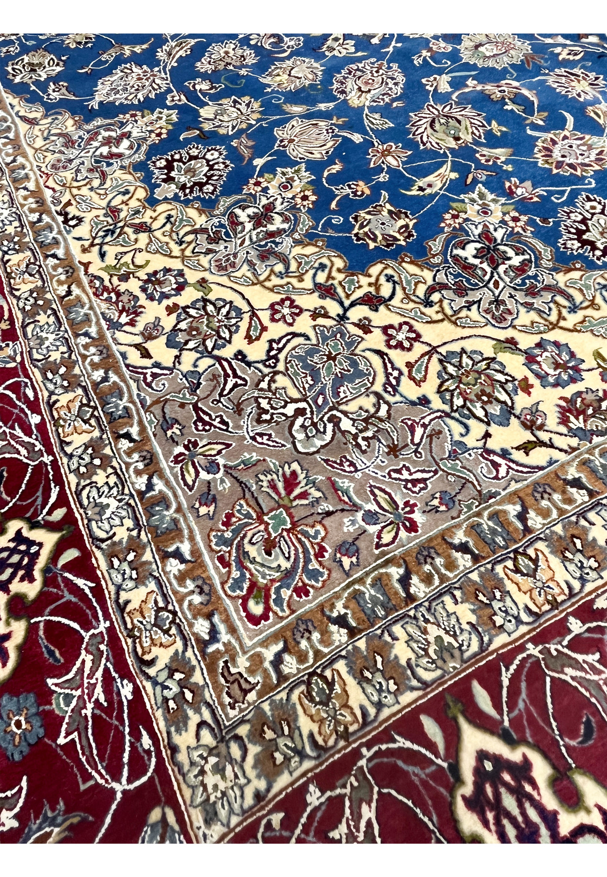 Inner border close-up revealing detailed beige, ivory, and floral motifs framing the blue field of the Isfahan rug.