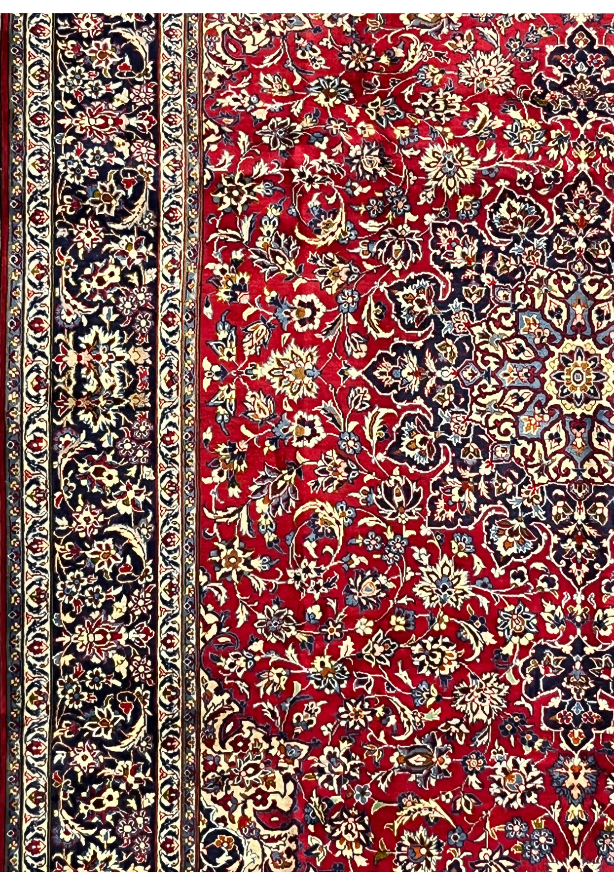 Side angle of Persian Isfahan rug highlighting medallion, floral patterns, and navy border design