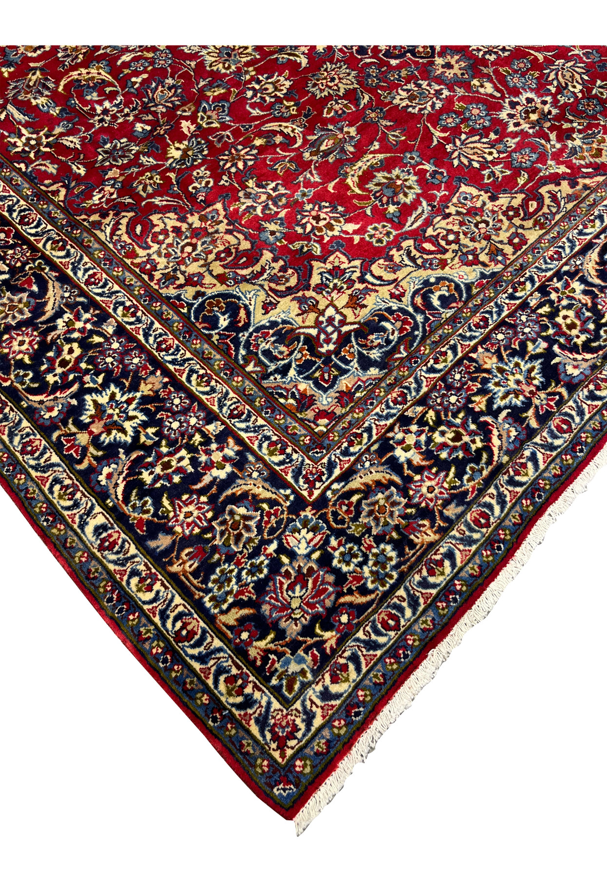 Corner section of Persian Isfahan rug showing navy border, floral blossoms, and ruby red field