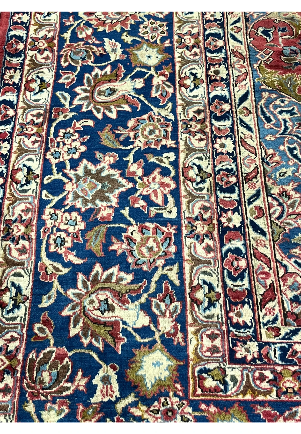 Close-up of the navy border on the Najafabad rug featuring classic Persian floral and palmette patterns.