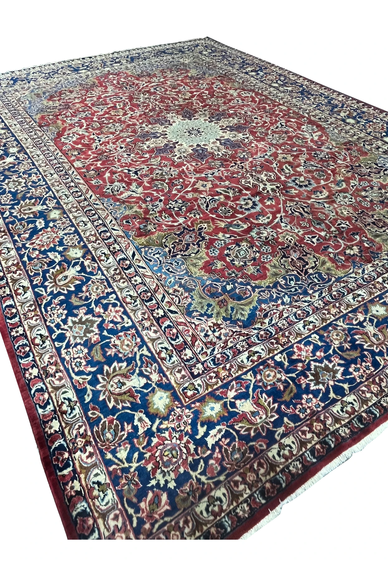 Angled view of the 9'9 x 14'5 Najafabad Persian rug highlighting the ruby field and strong navy border contrast.