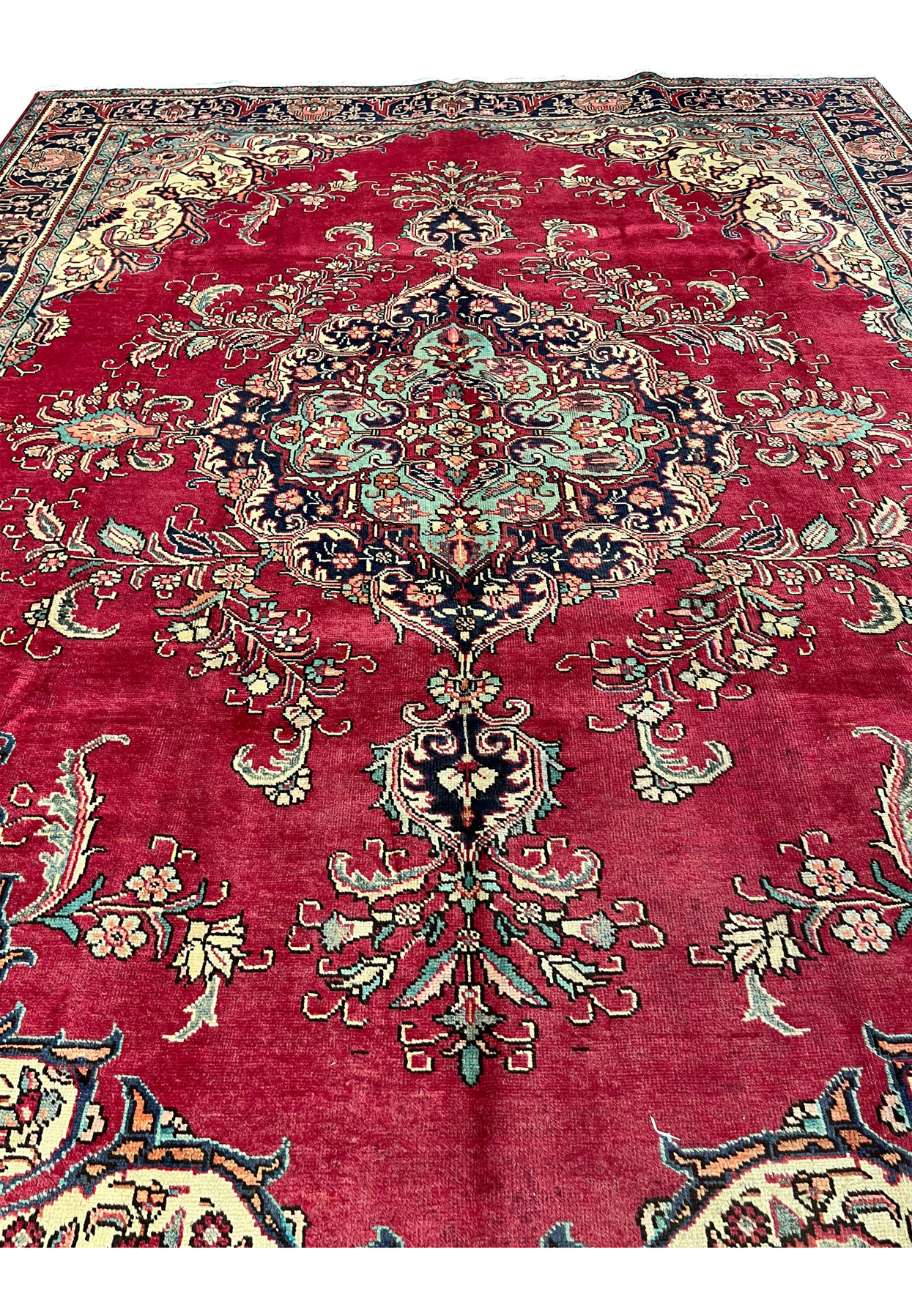 Side angle of the 10x13 Vintage Tabriz Rug showing low pile, patina marks, and floral structure.