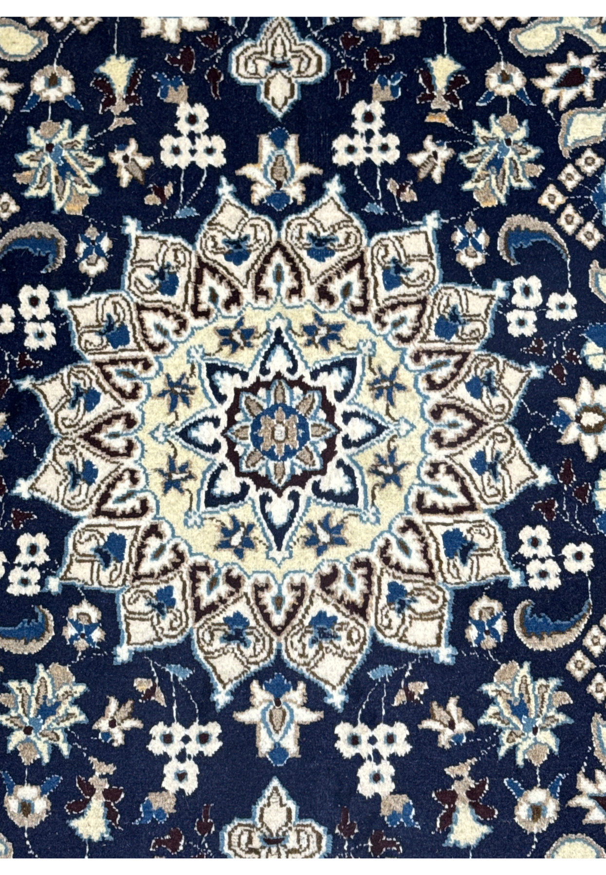 Close up of ivory and sky blue central medallion on royal navy Persian Nain rug