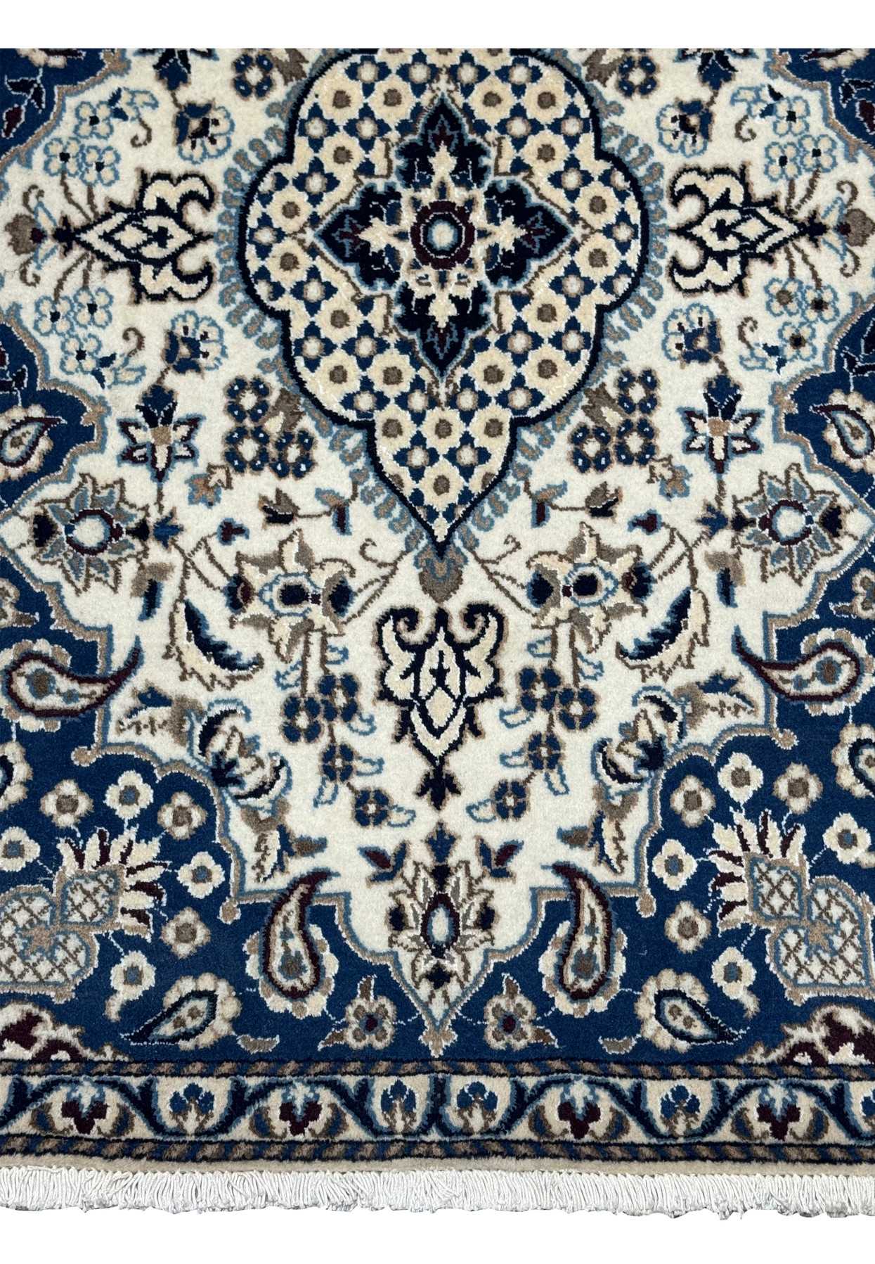 Lower section of Persian Nain rug showing ivory field, powder blue blossoms, taupe vines, and navy border with floral detailing