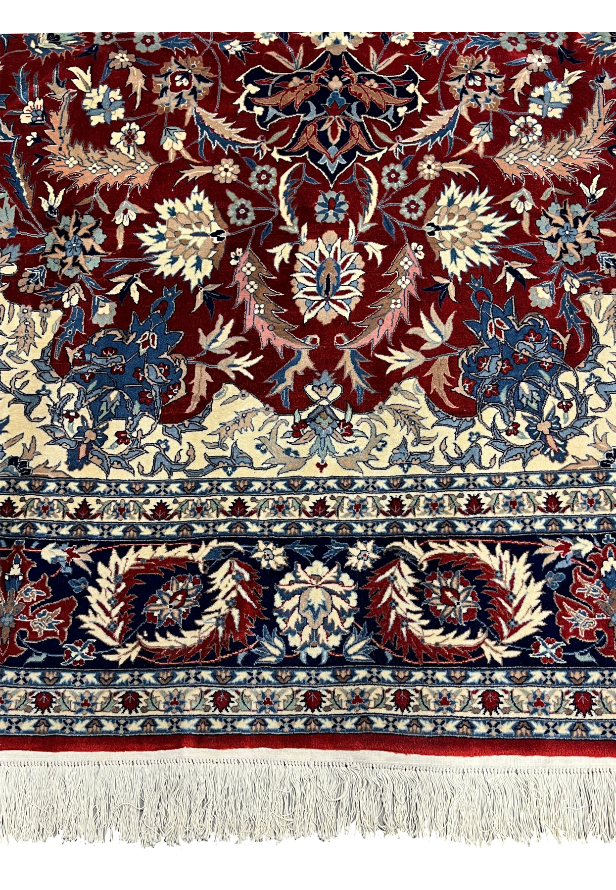 Lower border detail of Persian Isfahan rug showing navy floral guard borders, ivory accents, and hand knotted wool fringe