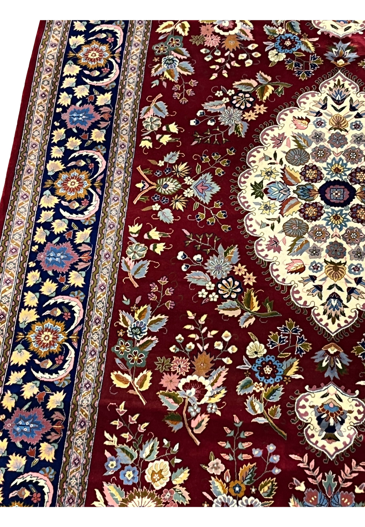 Close-up of burgundy field showing intricate floral motifs in wool and silk